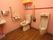 トイレには、便座と男性用小便器の２種類がある。赤い色となっている壁近くには２つの木製の手すりが設置されている。