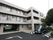 施設外観は３階建てになっており、照明がついている部屋もいくつかある。地上部分には１台の車が停まっている。