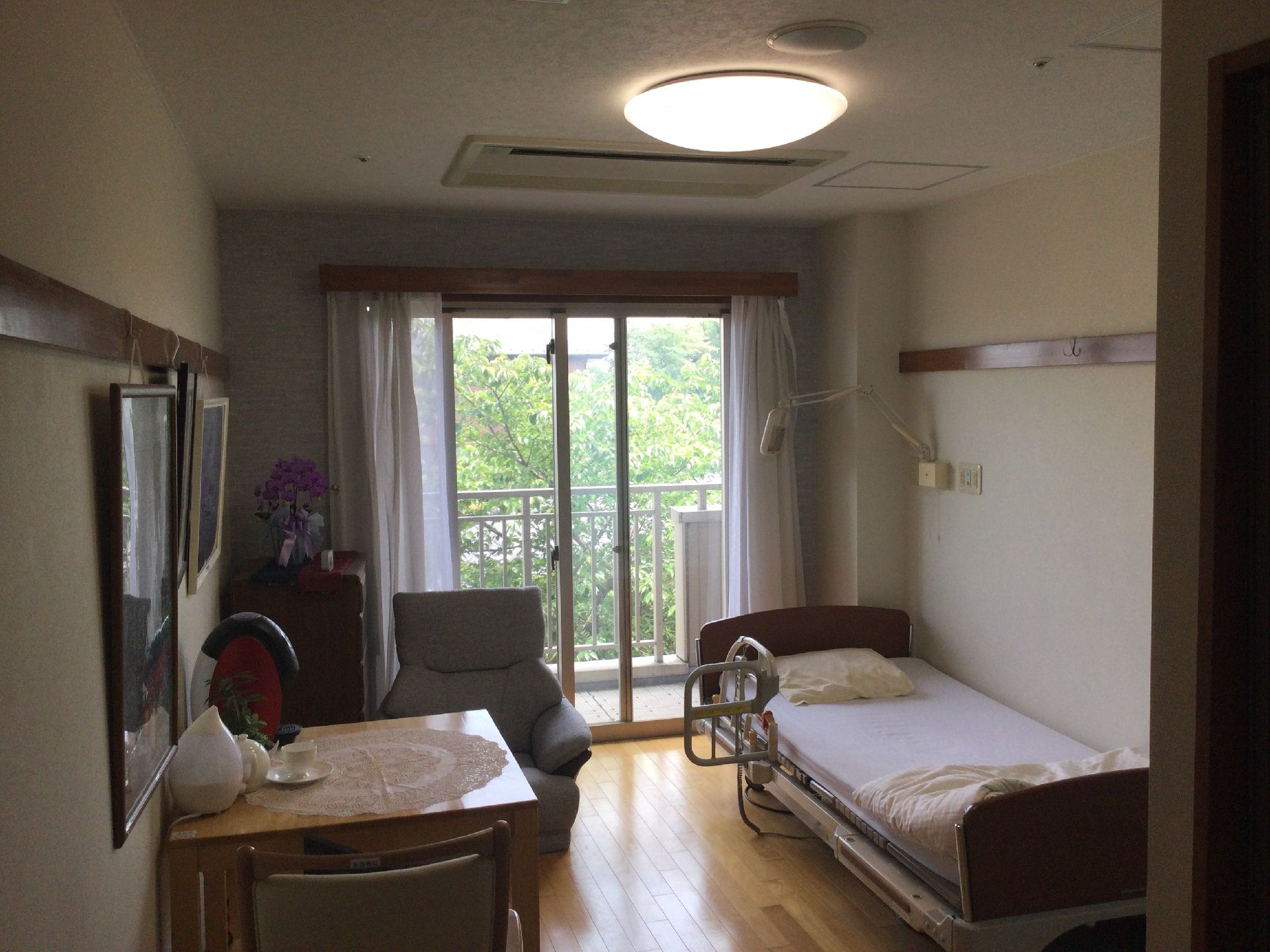 居室は天井部分の照明がついていて、明るくなっている。部屋内は様々な家具が置かれており、テーブルのところにはマットが敷かれている。