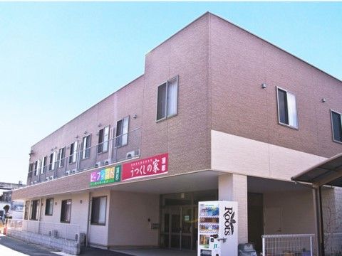 「うつくしの家 蒲郡」の外観。赤茶色とピンク色の外壁が塗られており、1階フロアを車を収容できる。