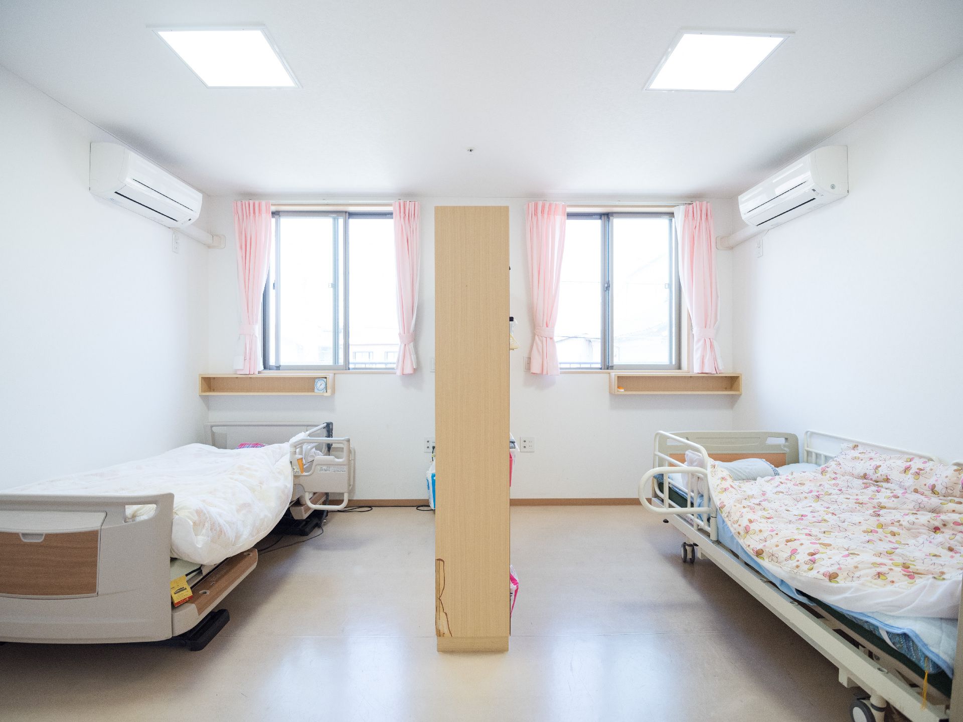 一つの部屋が背の高い収納で間仕切りされ、左右にベッドが置かれた個室