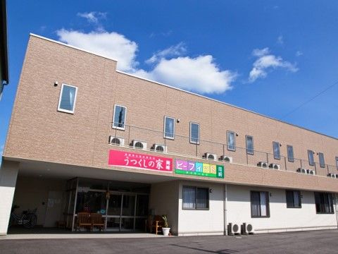 1階は白、2階はブラウンに塗られ、玄関の上に2階部分が張り出した形になっている外観