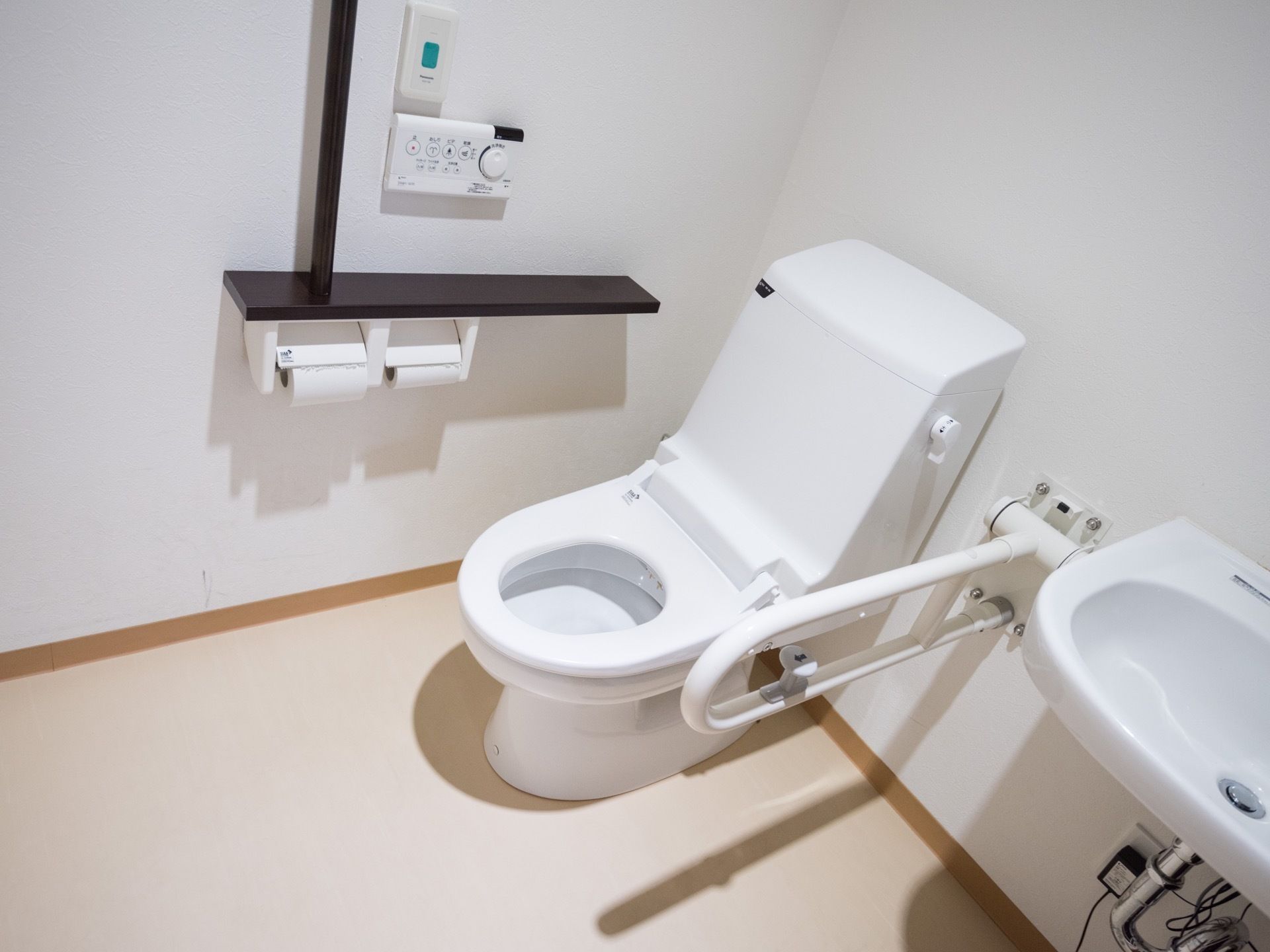 掃除が行き届いた清潔感のあるトイレに、ウォシュレット機能付き便座が設置されている。また、手すりが備え付けられている。