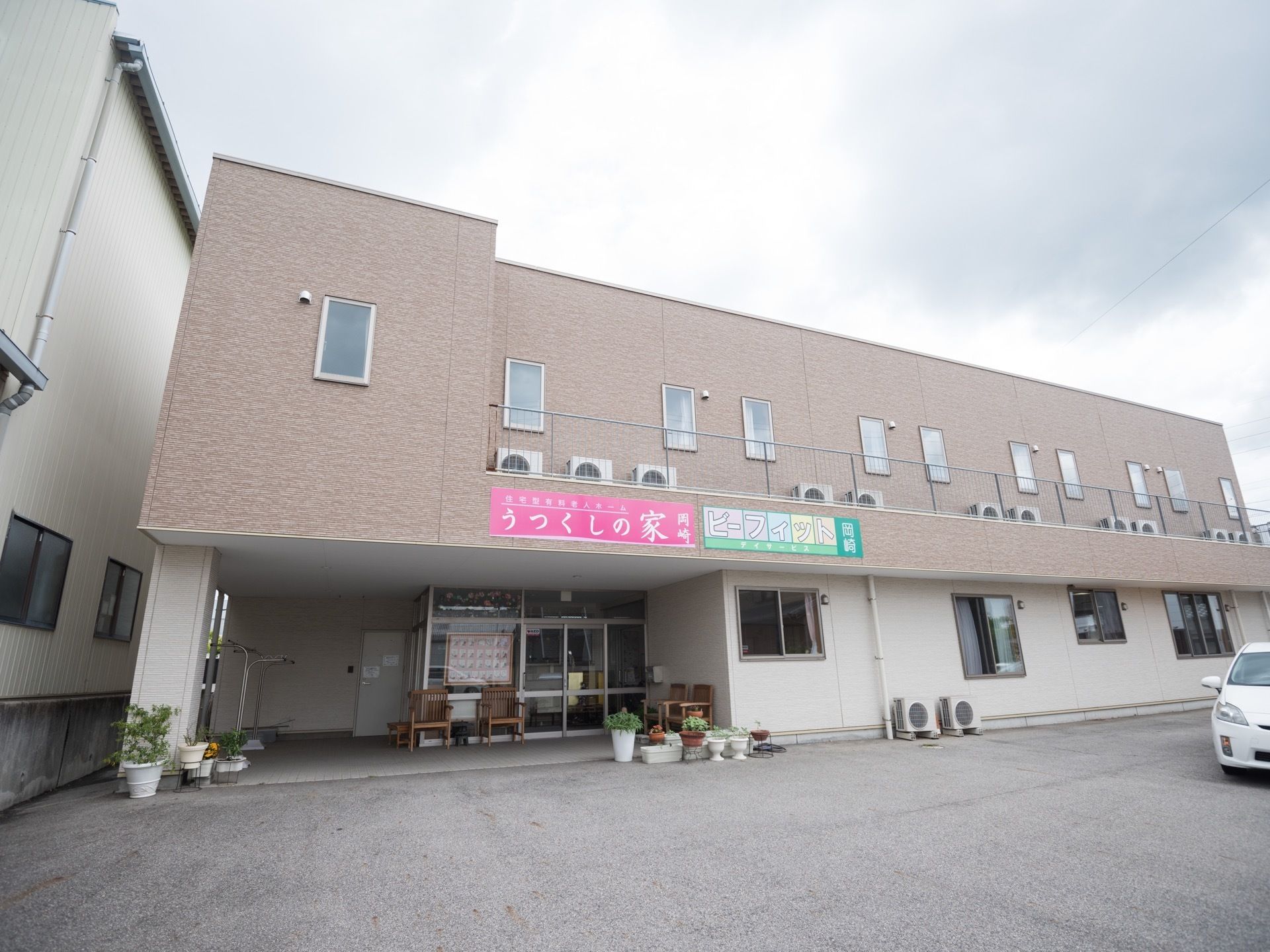 １階部分に玄関があり、ガラス張りのドアが設置されている。施設の敷地内はバリアフリー設計で、段差がない。駐車スペースも確保されている。