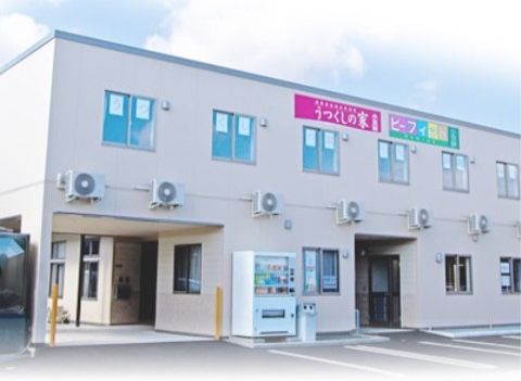 玄関部に2階が張り出していて自動販売機が置かれている建物