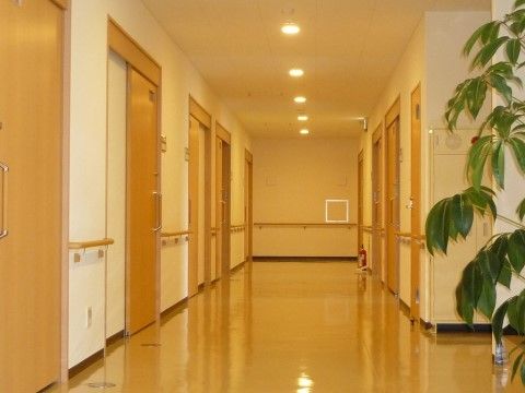 両側に居室につながるドアが並び、天井にスポット照明が埋め込まれた廊下