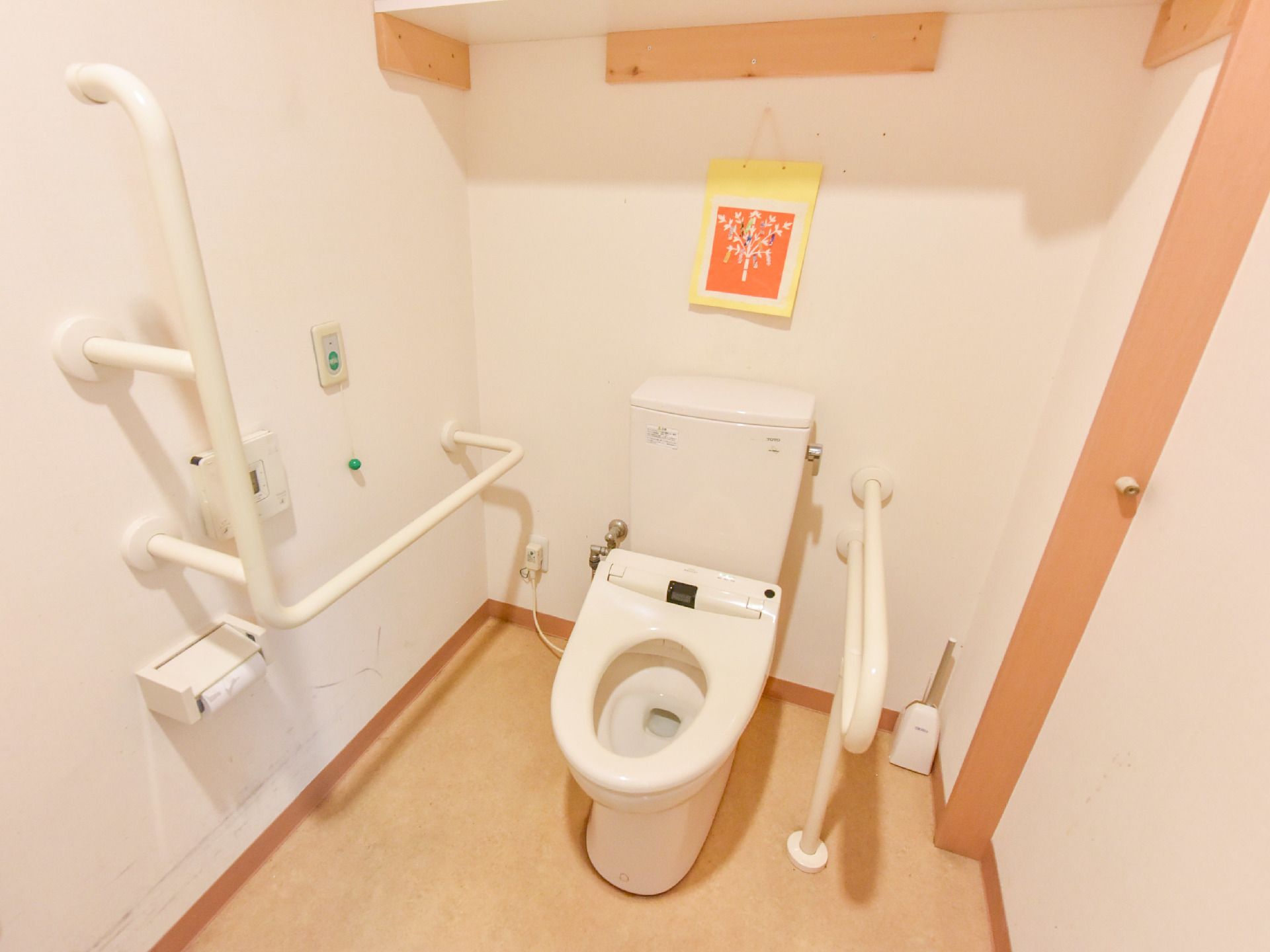 トイレの便座の左右には縦と横の手すりが設置されているバリアフリーな作りになっており、立ち座りの際の負担を軽減することができる。