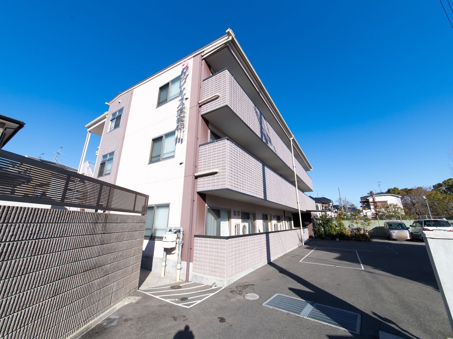 温かみのある色調の3階建の建物には、日の光がよく当たっている。道路もきれいに舗装され、車椅子をご利用の方もスムーズに移動が可能。