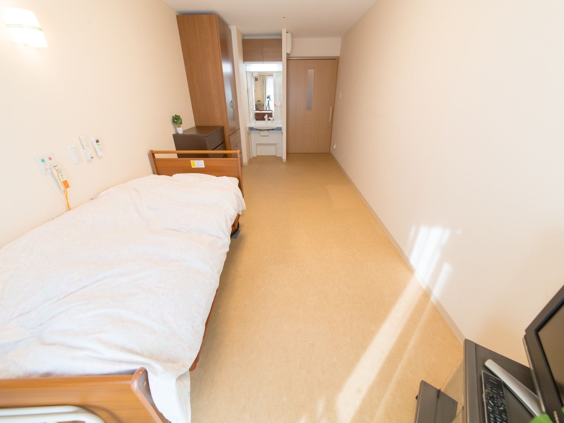電動ベッドである。ベッドサイドに広いスペースが設けてあるので車椅子をご利用の方も安心である。テレビが設けられている。