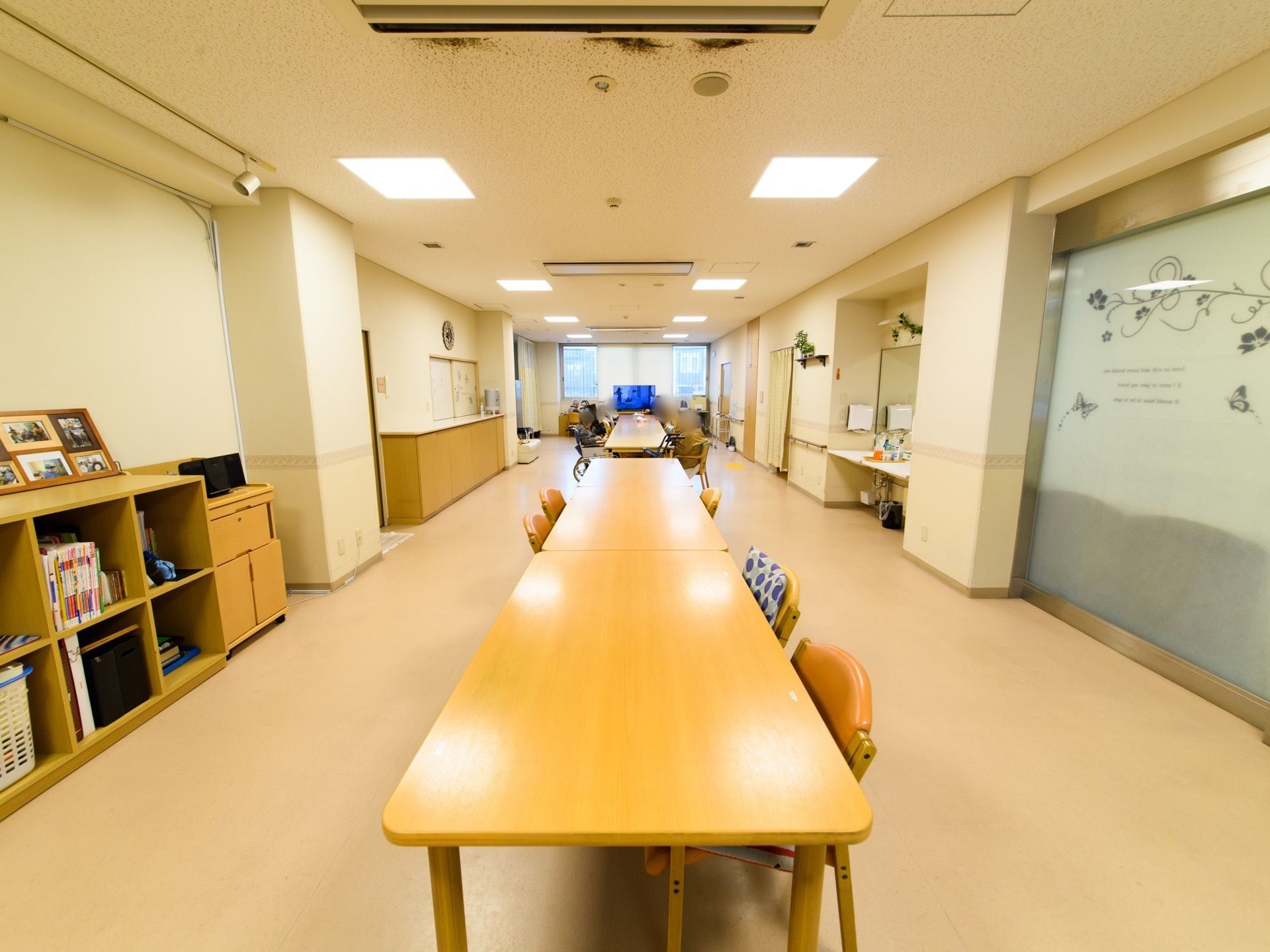 広いリビングは横長の間取りになっており、ダイニングテーブルが並べられている。壁際には、洗面台が設置されている。