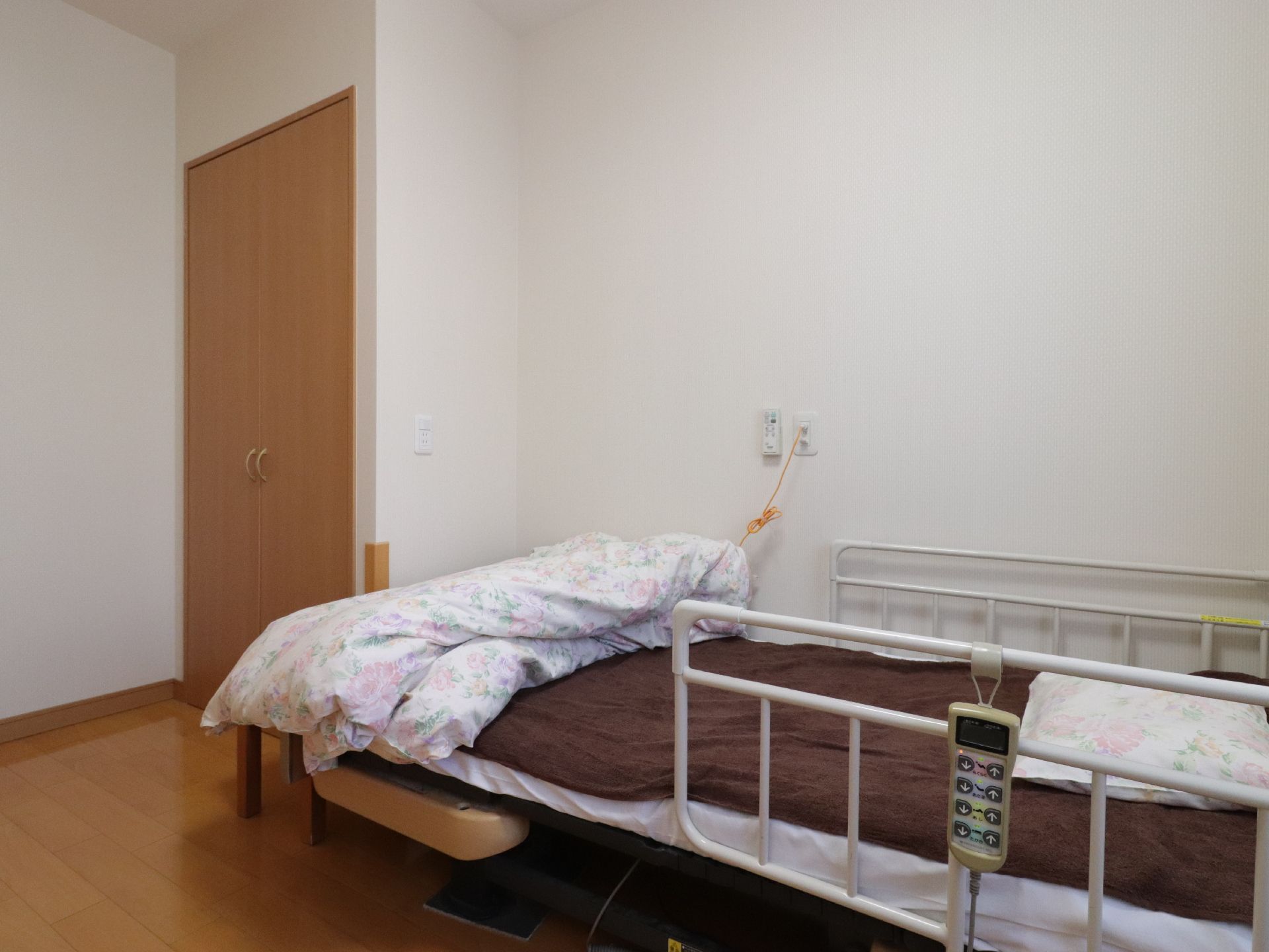 居室に用意されたベッドは介護仕様となっている。左右にある転落防止柵にはコントローラーが取り付けられている。