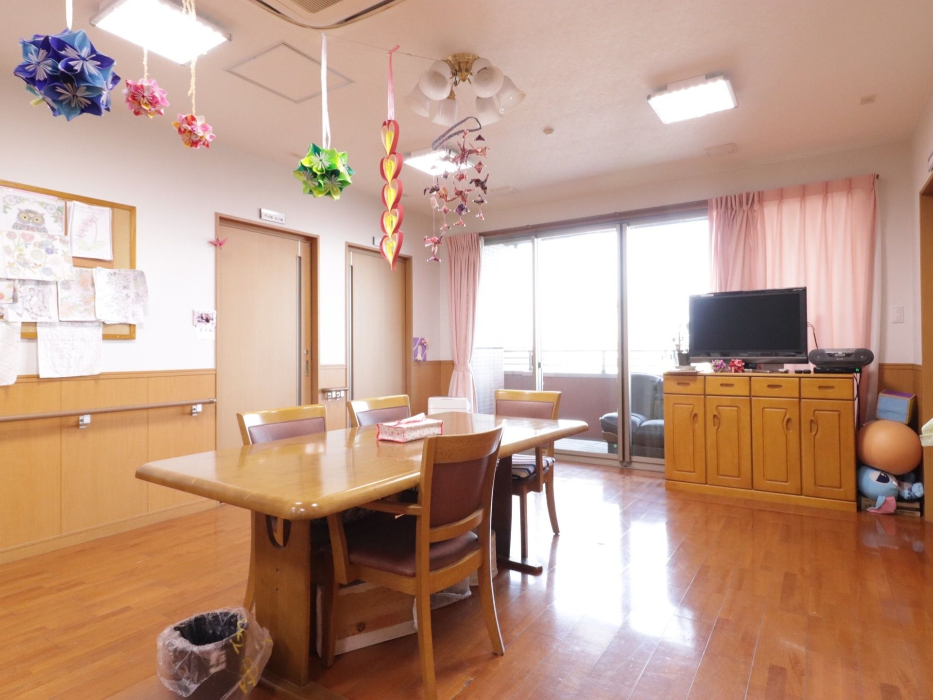 机1台と椅子が4つ、テレビが設置してある。大きな窓から光りが入り、明るい部屋になっていてベランダと繋がっている。