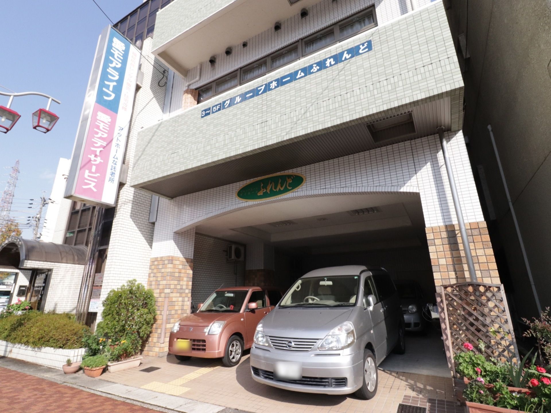 建物の一階部分は駐車スペースである。駐車スペースの上部と二階バルコニーに、施設の名称が表示されている。