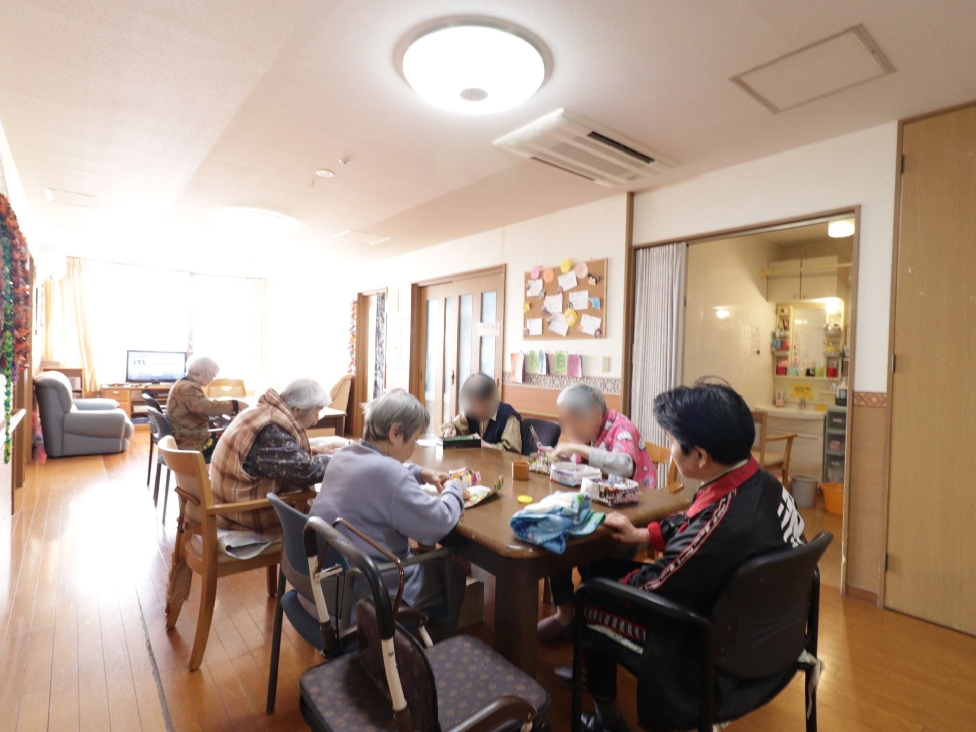 手前にダイニングテーブルがあり、奥にテレビやソファが置かれている。ダイニングの横には広い洗面所がある。