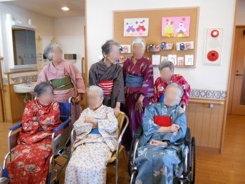 浴衣を着て車いすに座る3人の高齢者と、その後ろに立つ浴衣姿の4人の高齢者