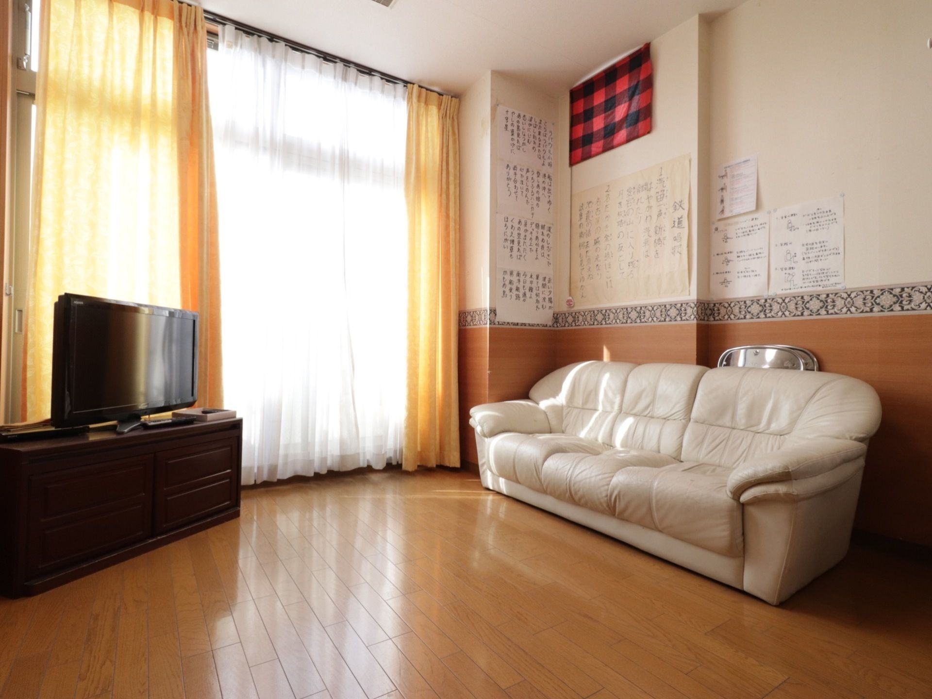 窓際に大きな白いソファが置かれており、その前にテレビが設置されている。壁には歌の歌詞や、体操を図解した紙が張られている。