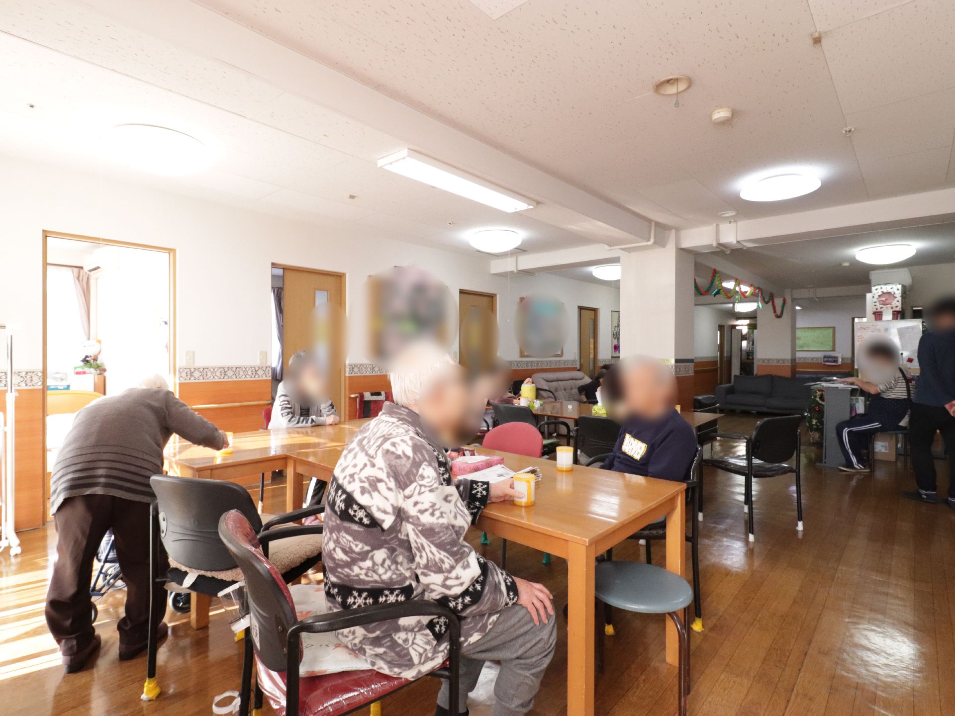 リビングには茶色いテーブルと椅子が用意されている。椅子は背もたれ付きと背もたれのない物が並べられている。