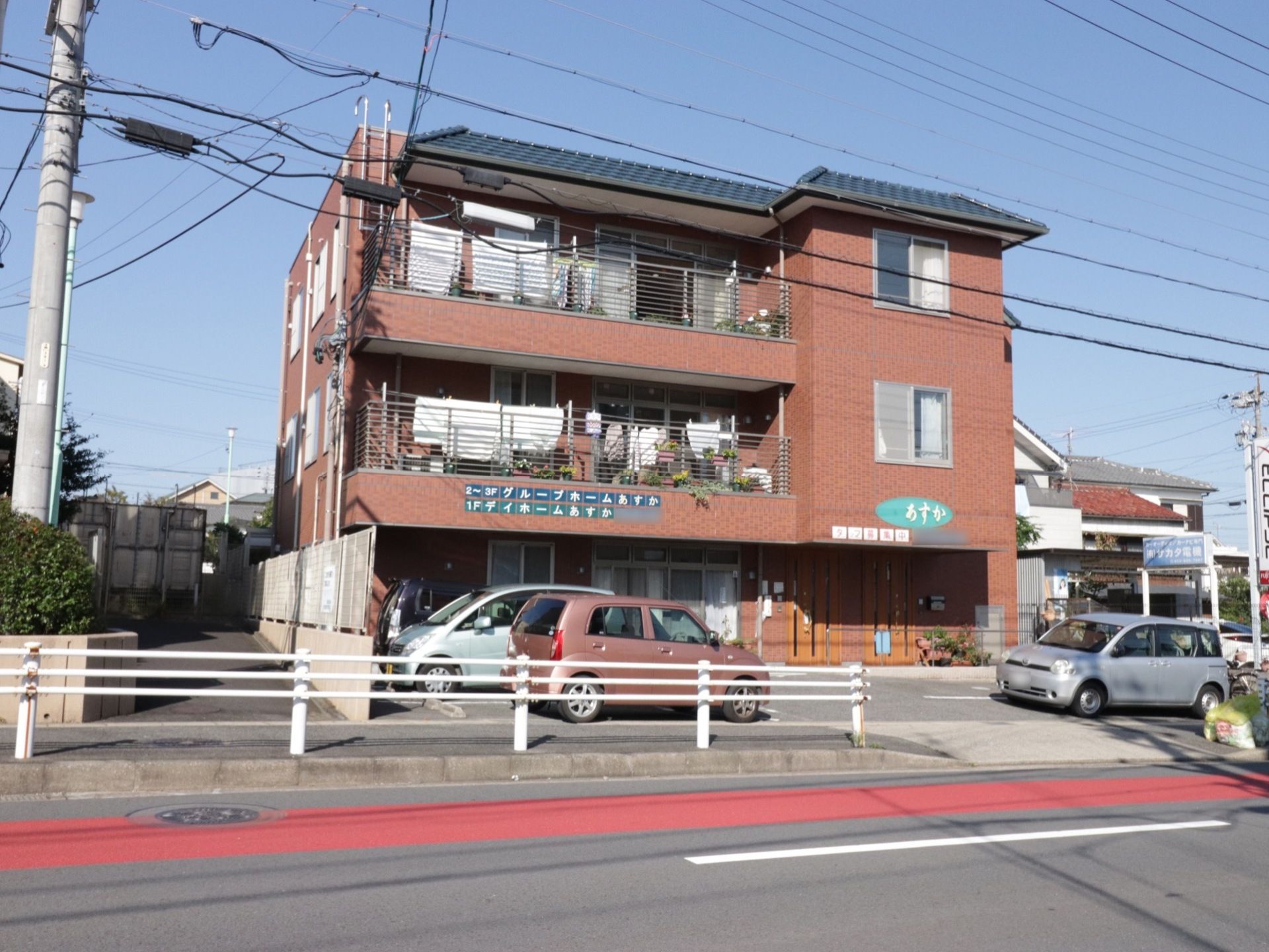 施設は３階建て。外壁は煉瓦調になっている。建物の前に数台停められる駐車場がある。玄関前には段差や傾斜がない。