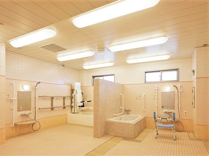座ったまま入浴できる設備が備えられたベージュ基調の浴室