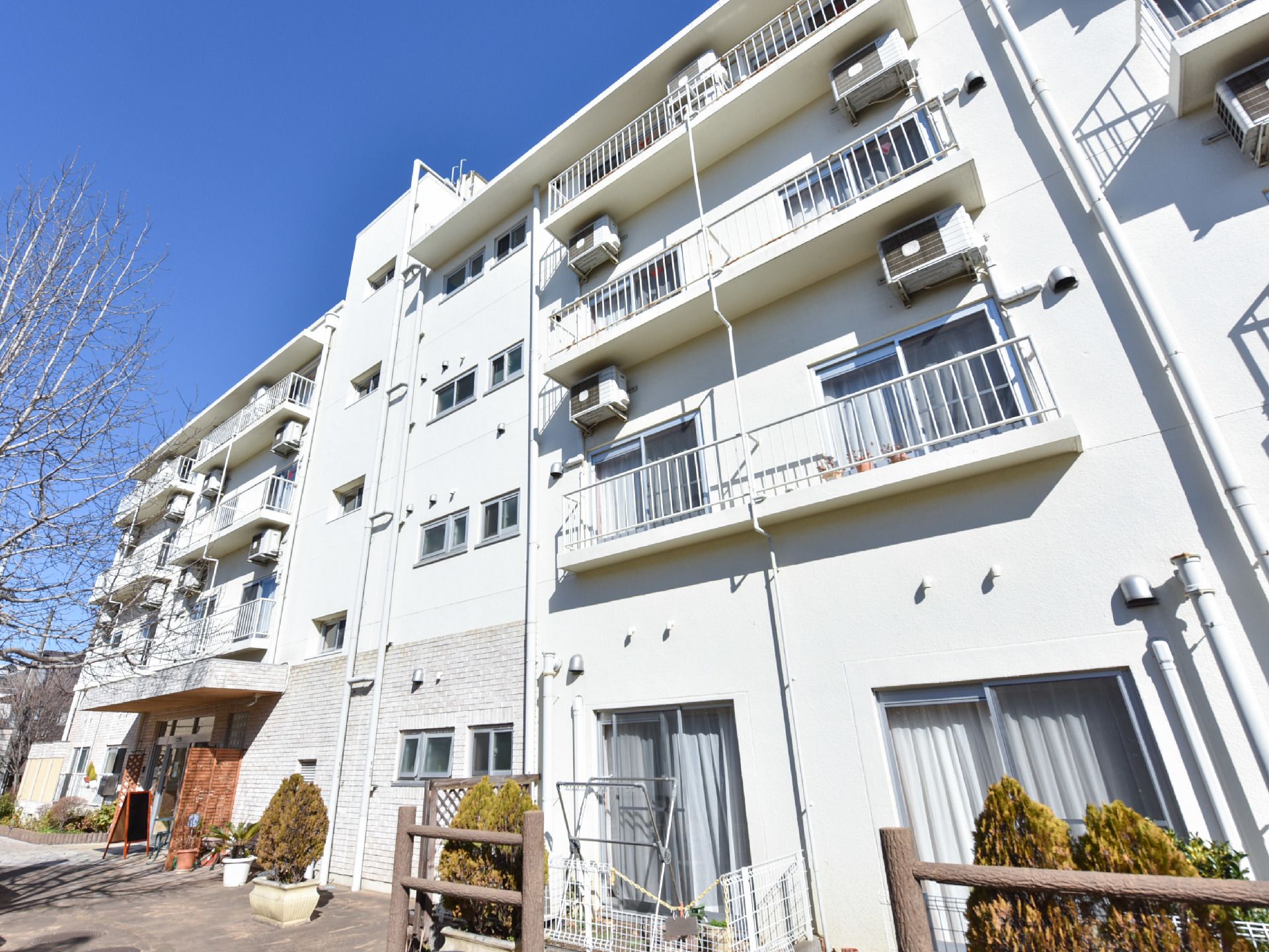 施設の外壁は白い壁で、鉄骨鉄筋コンクリート造になっている。敷地には木々が植えられており、緑が溢れている。