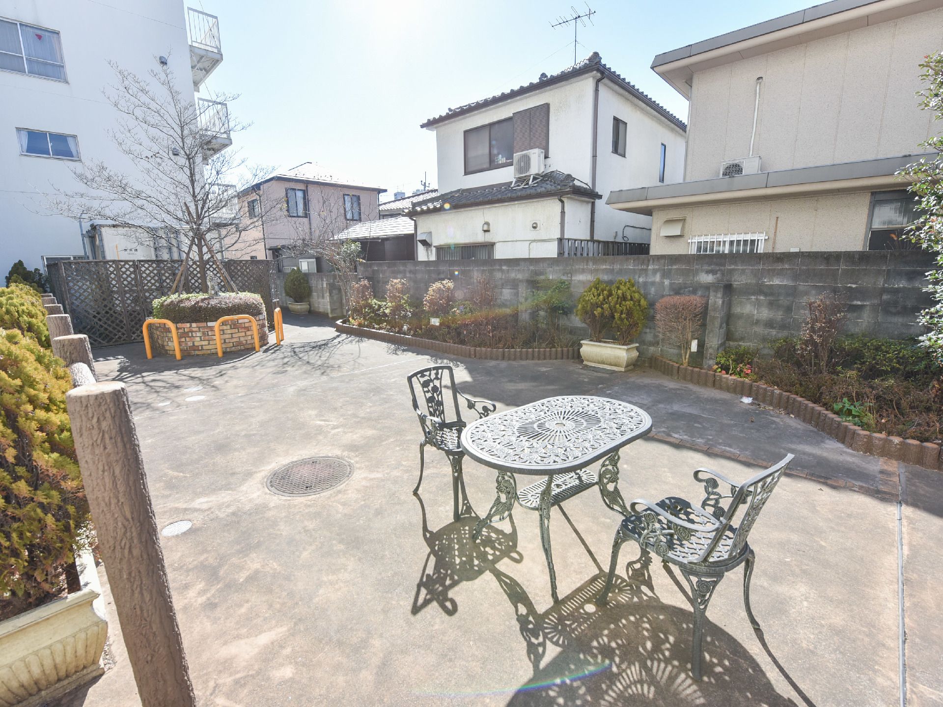施設のエントランスから出た左手に、広々としたガーデンスペースがある。敷地内の庭を挟んで、住宅街が広がっている。
