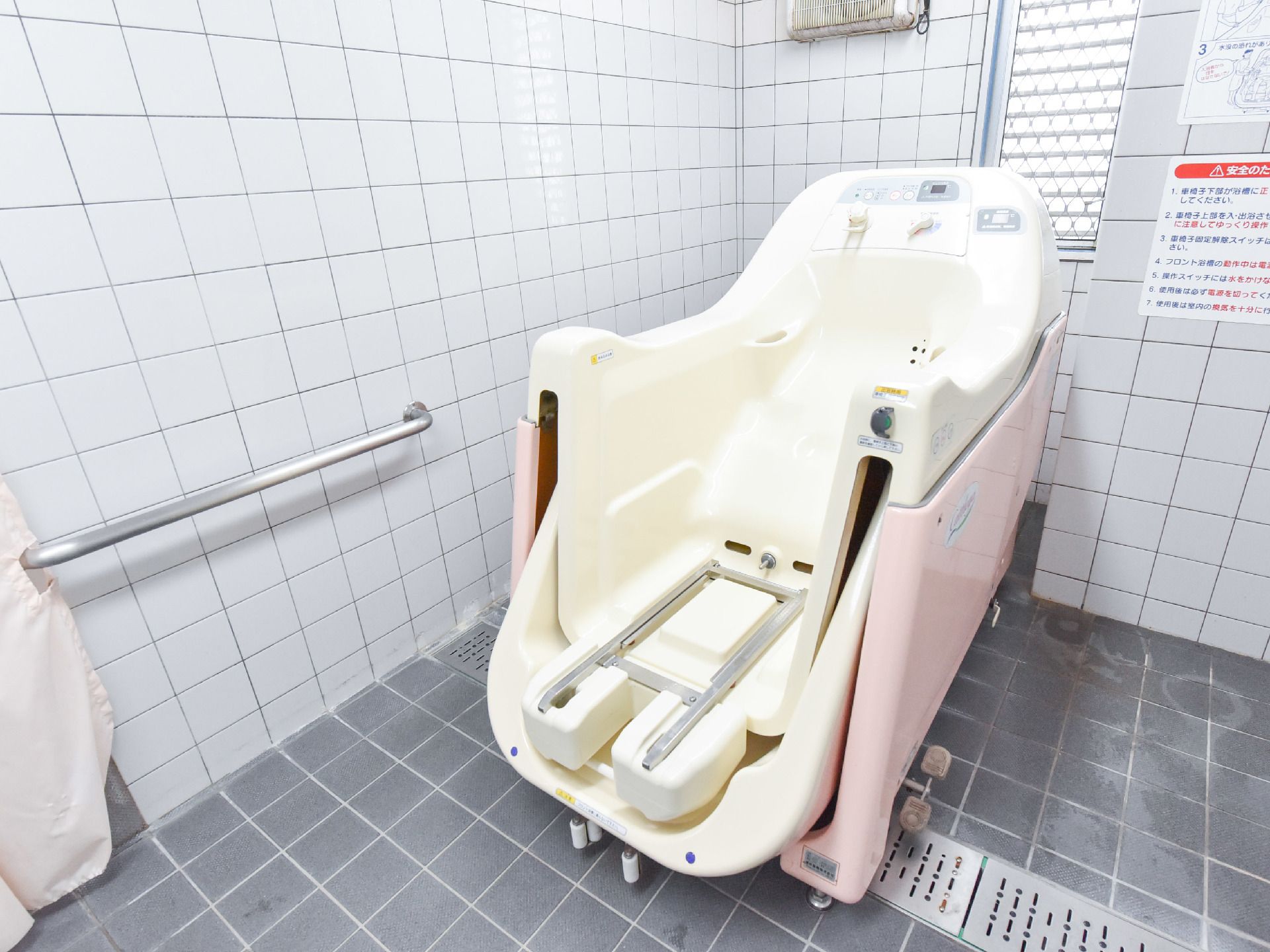 機械浴のあるバスルームは、ストレッチャータイプの車イスに乗ったまま入浴できる、介護用入浴機器を設置している。