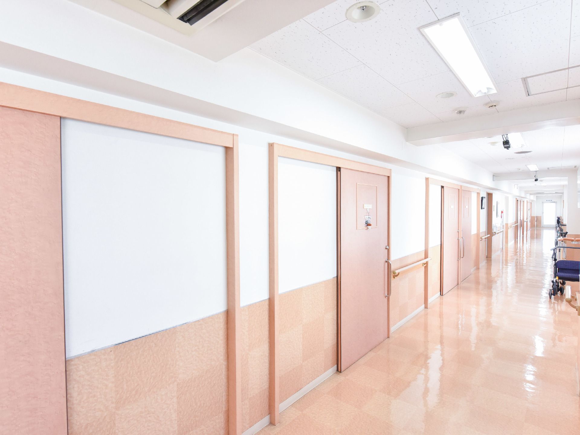 居室のドアは高齢者でも開け閉めしやすい、スライド式を採用している。また通路の廊下にも、空調設備を完備している。