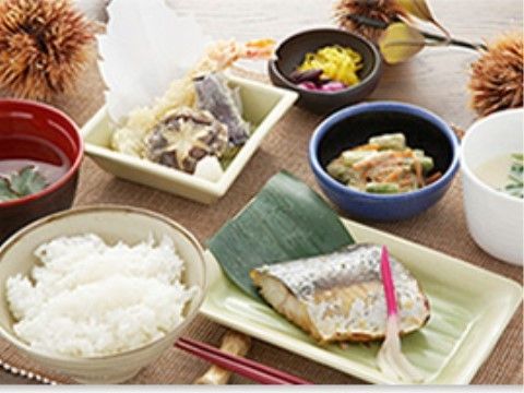 焼き魚をメインとし、他に茶わん蒸し、天ぷら、胡麻和えと野菜の小鉢、ご飯とお味噌汁が並んでいる。テーブルにはイガ栗が飾られている。