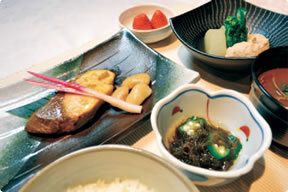 葉生姜をのせた焼き魚と野菜の煮物が付いたメニュー