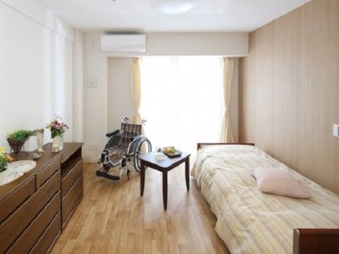 カーテンの取り付けられた居室の窓からは、暖かな日の光が注ぎ込んでいる。居室内は、車椅子をご利用の方が移動できるほどの十分なスペースがある。