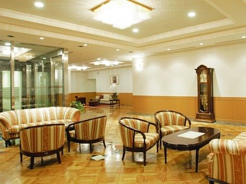 天井に豪華なシャンデリアが設置され、右側に大きな時計が置かれたラウンジ