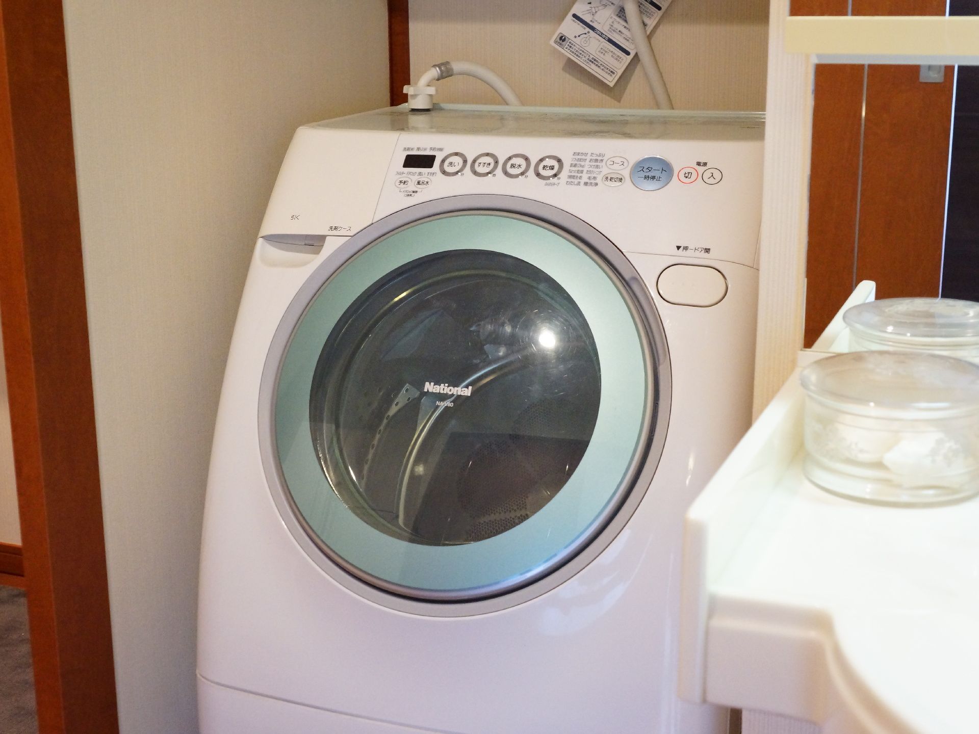 高級マンション並みの広さと設備を整えた二人用居室には、洗面台の横に大手メーカーのドラム式洗濯機が用意されている。