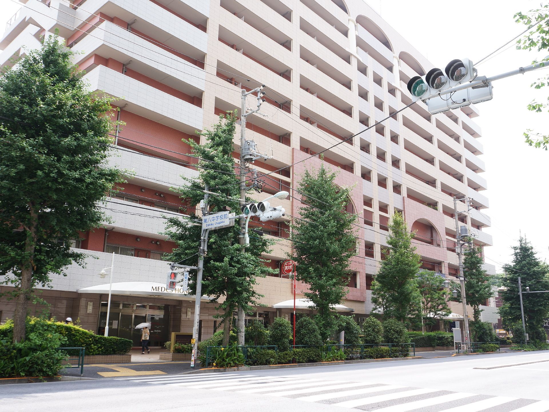 外から見た施設の建物は、マンションのようである。外側の通路などの壁は、白っぽく、内部のドアと廊下の周りの壁はサーモンピンクだ。