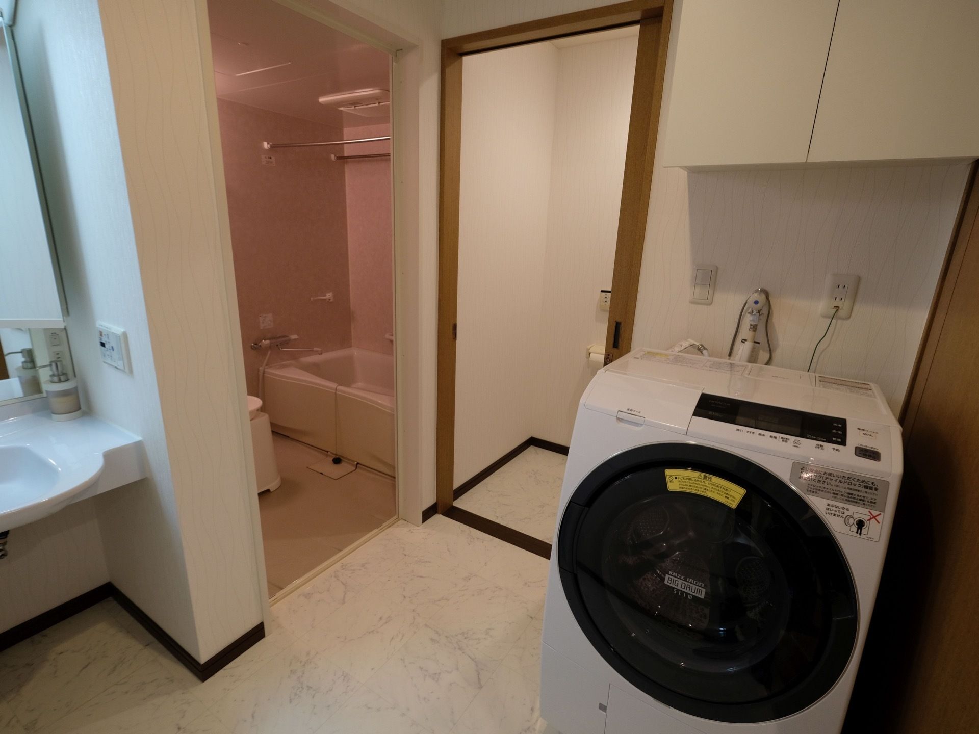 脱衣所にはドラム式洗濯乾燥機と洗面台がある。浴室のすぐ隣にトイレがある。浴室には手すりが取り付けられている。