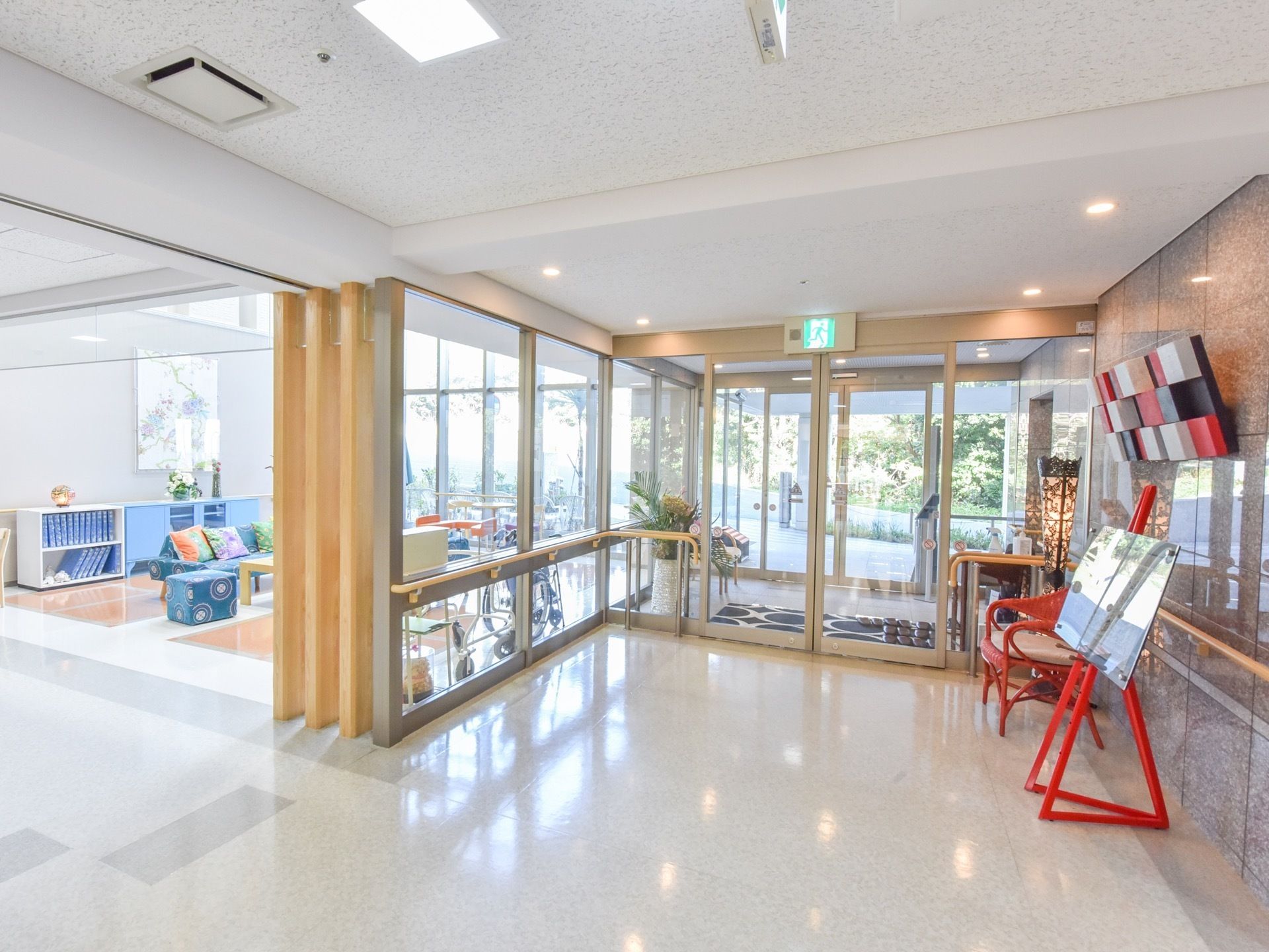 館内からの玄関の写真。通路は広く清掃が行き届いた清潔な空間で、隣接するロビーとの間はガラス張りで開放的である。