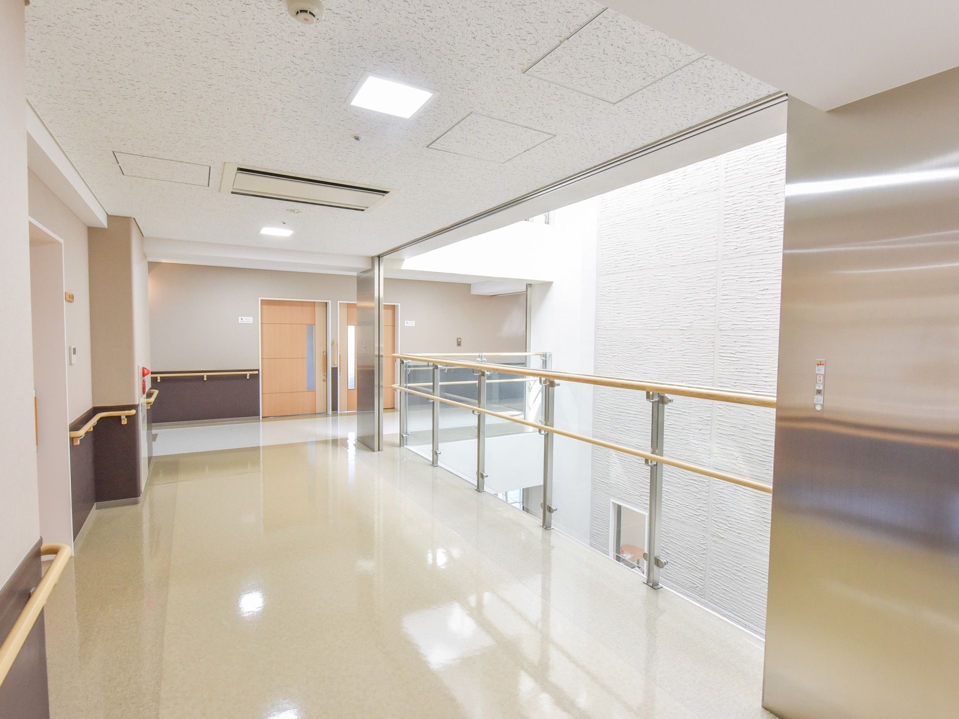 壁と天井は白く、床は淡いクリーム色である。通路脇には吹き抜けがあり建物内部が明るく開放的な雰囲気である。