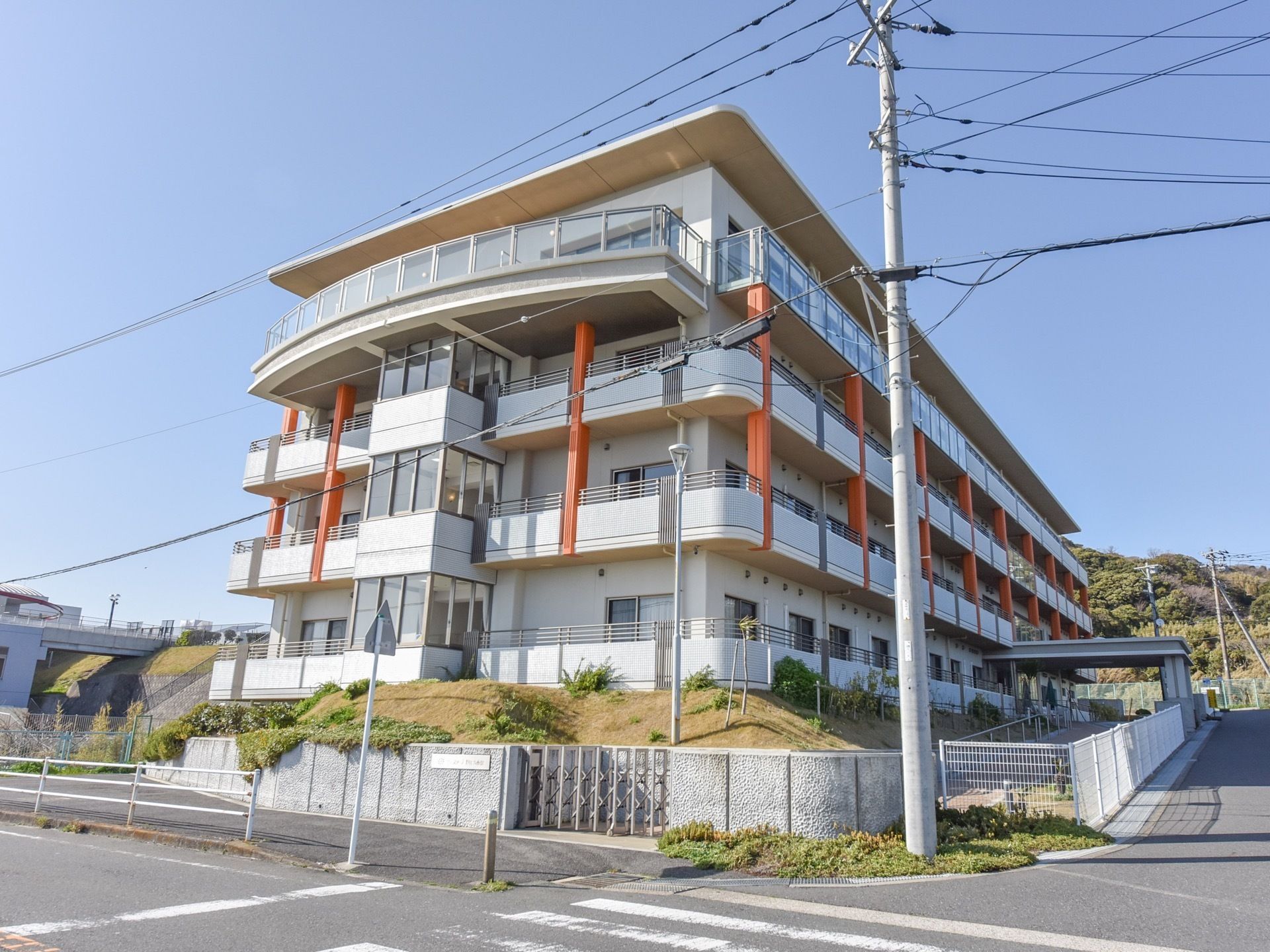 周りは自然豊かで、日当たりのよい鉄筋コンクリート造りの４階建てである。白地にオレンジの柱がモダンなつくりである。