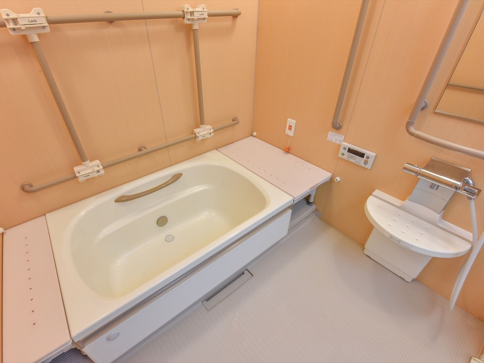 壁の縦横に手すりが設置されている明るく広々とした浴室には、ゆったりとした浴槽が置かれており、ゆったりと入浴することができる。