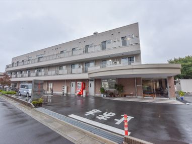 閑静な住宅街の道路に面した敷地に建てられている施設の外観。広々とした敷地があり、敷地内に駐車スペースがある。