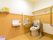 トイレは清潔で広々としており、便座の周囲には背もたれやひじ置きも設置されている。手すりも付いているので、立ち上がる時に安心である。