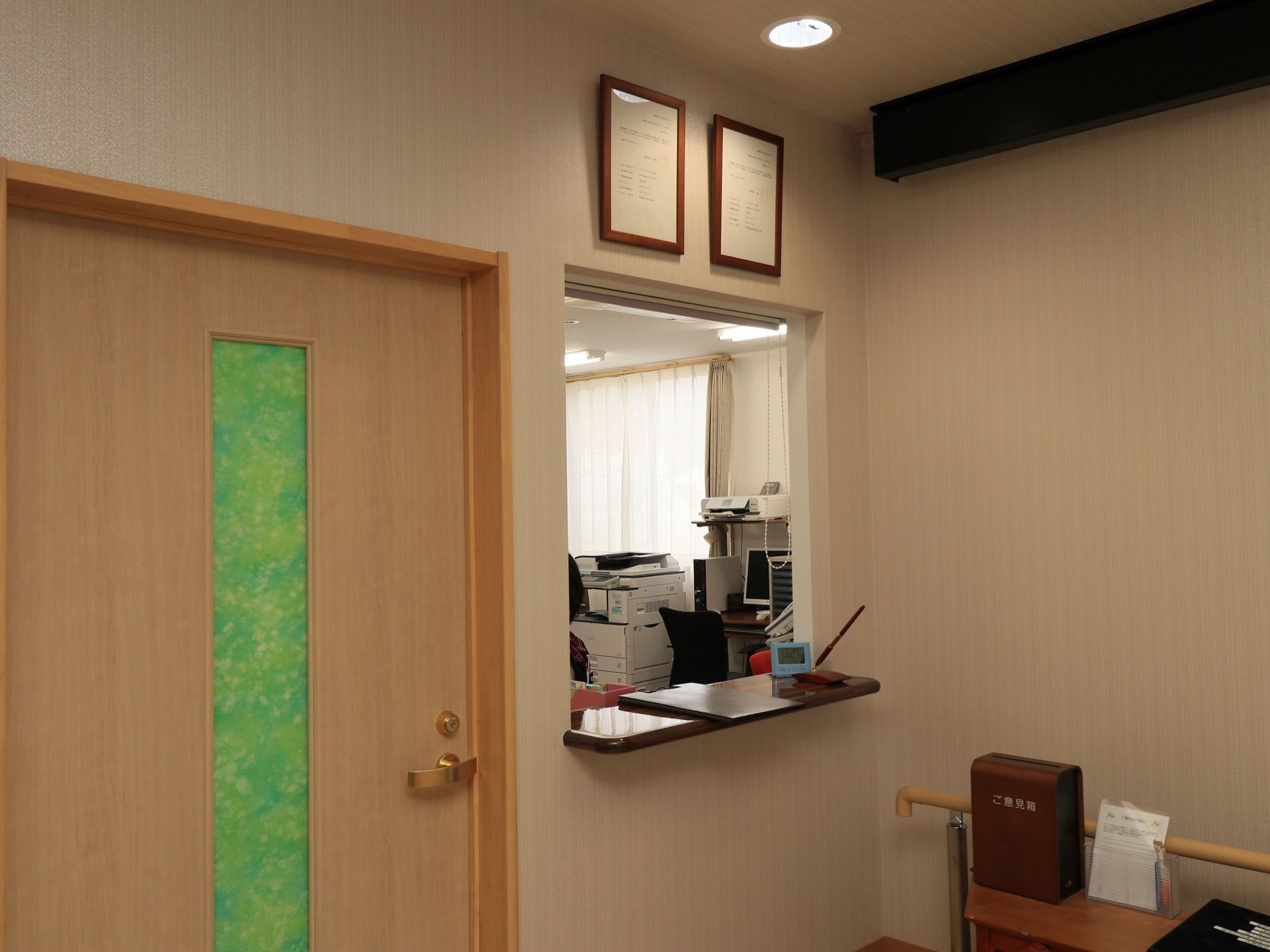 受付の奥はスタッフルームになっており、カウンターにはペンが置かれている。壁際に手すりが設置されている。