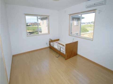 二つの窓がある明るい部屋には、エアコンを取り付けている。落下防止用柵を取り付けたベッドと、緊急時に職員を呼び出すボタンを設置している。