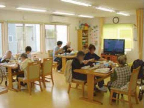 テレビのある食堂には、快適に過ごせるようにエアコン設置している。十分な大きさの机を配置し、食事をしやすくしている。
