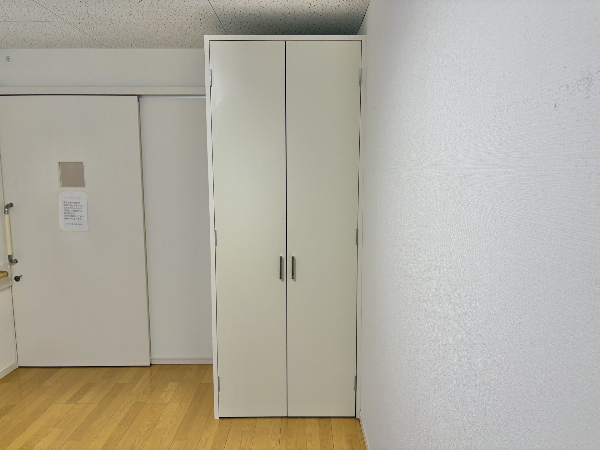 白い収納とドアの壁面