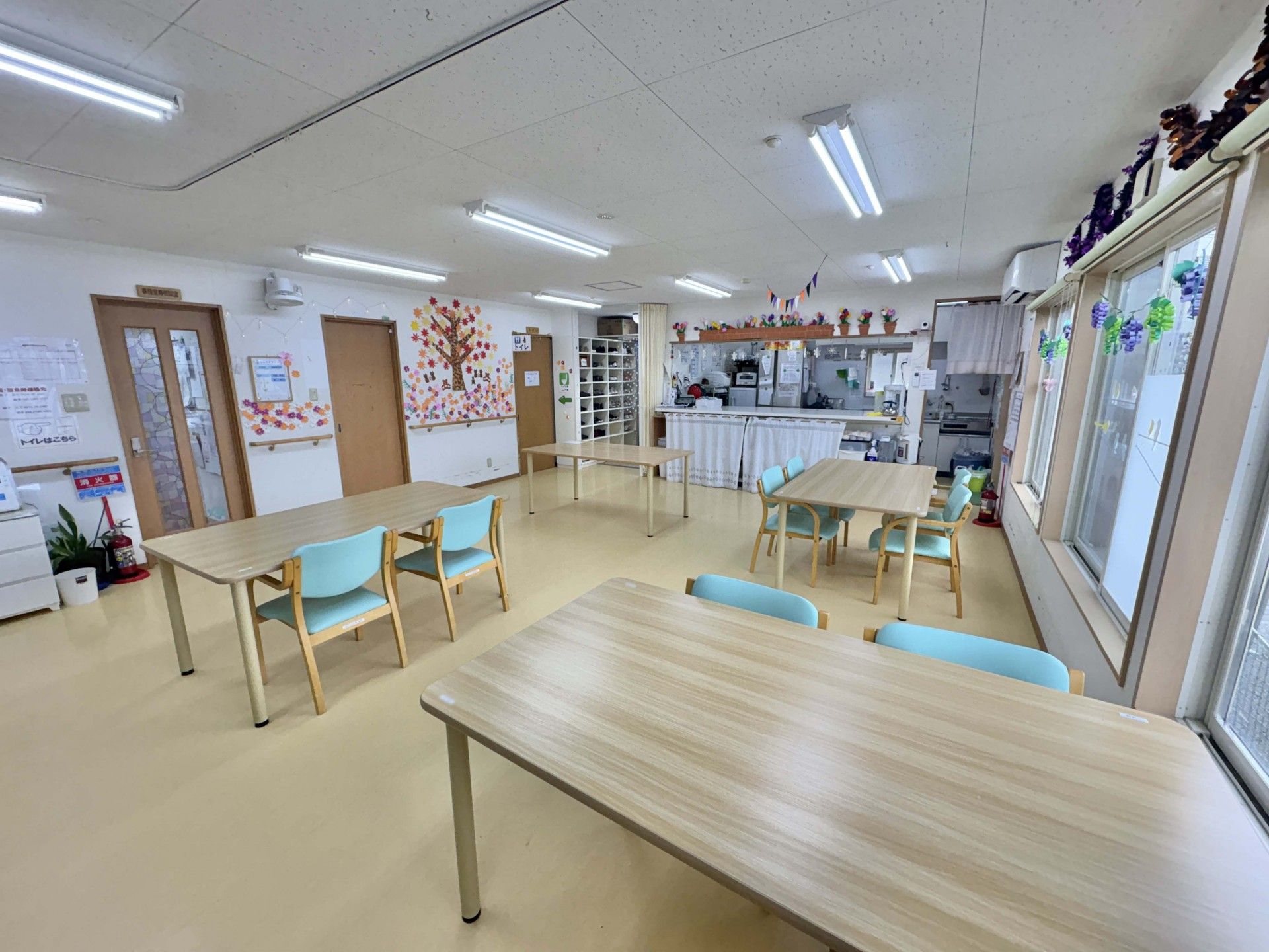 木陰を散歩する車椅子に乗った高齢女性と介助をする女性ヘルパー