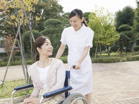 看護師が車イスを押している。