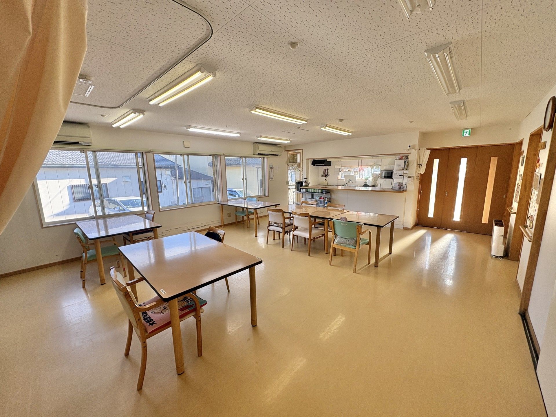 車椅子に座っている高齢女性と隣りに寄り添う男性ヘルパー