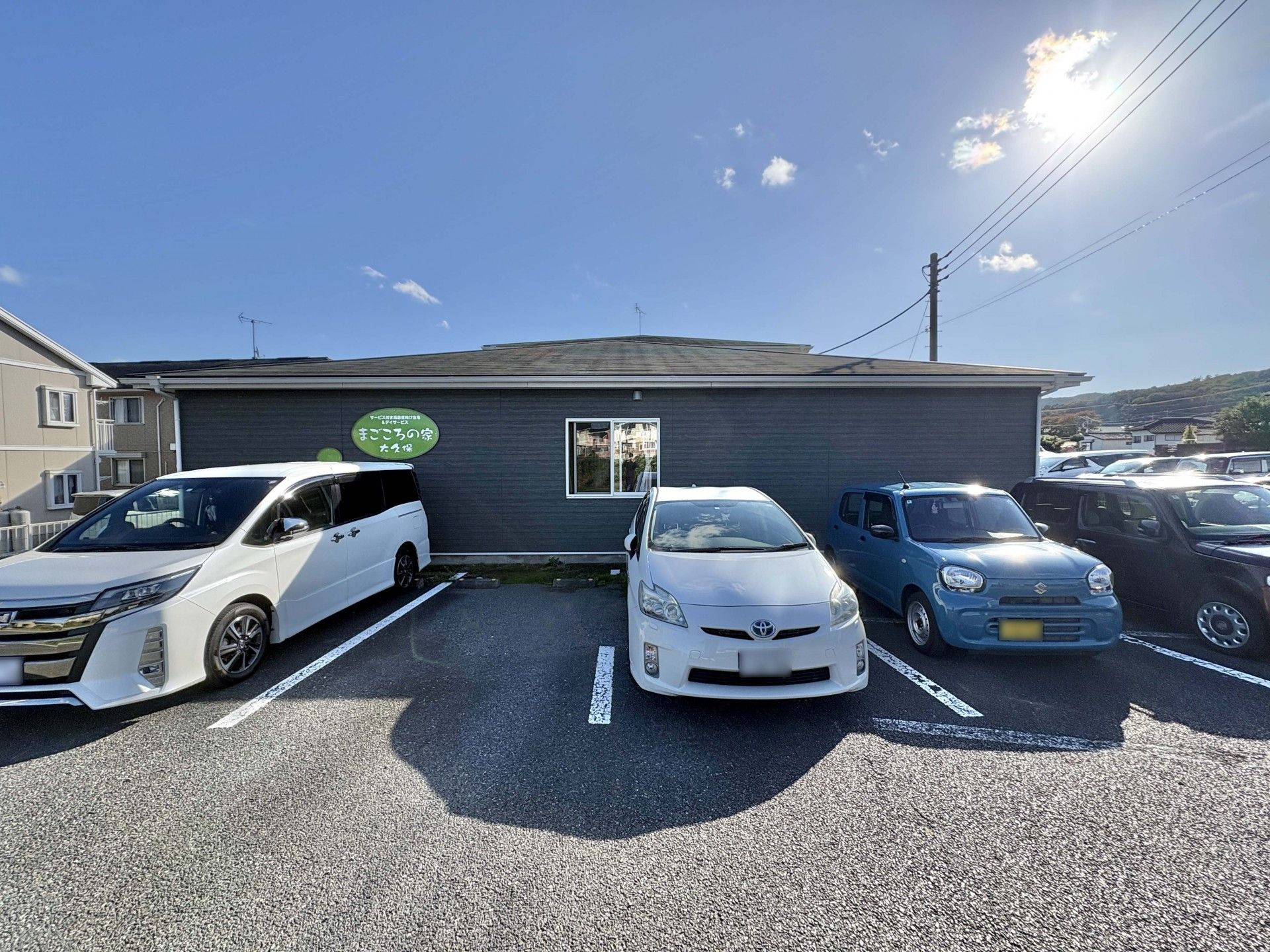 赤い車椅子に乗った高齢女性と介助をする女性ヘルパー