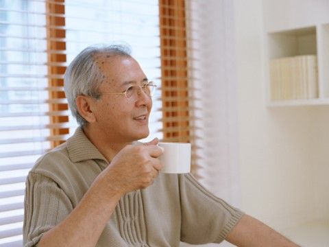 コーヒーを飲む高齢者。