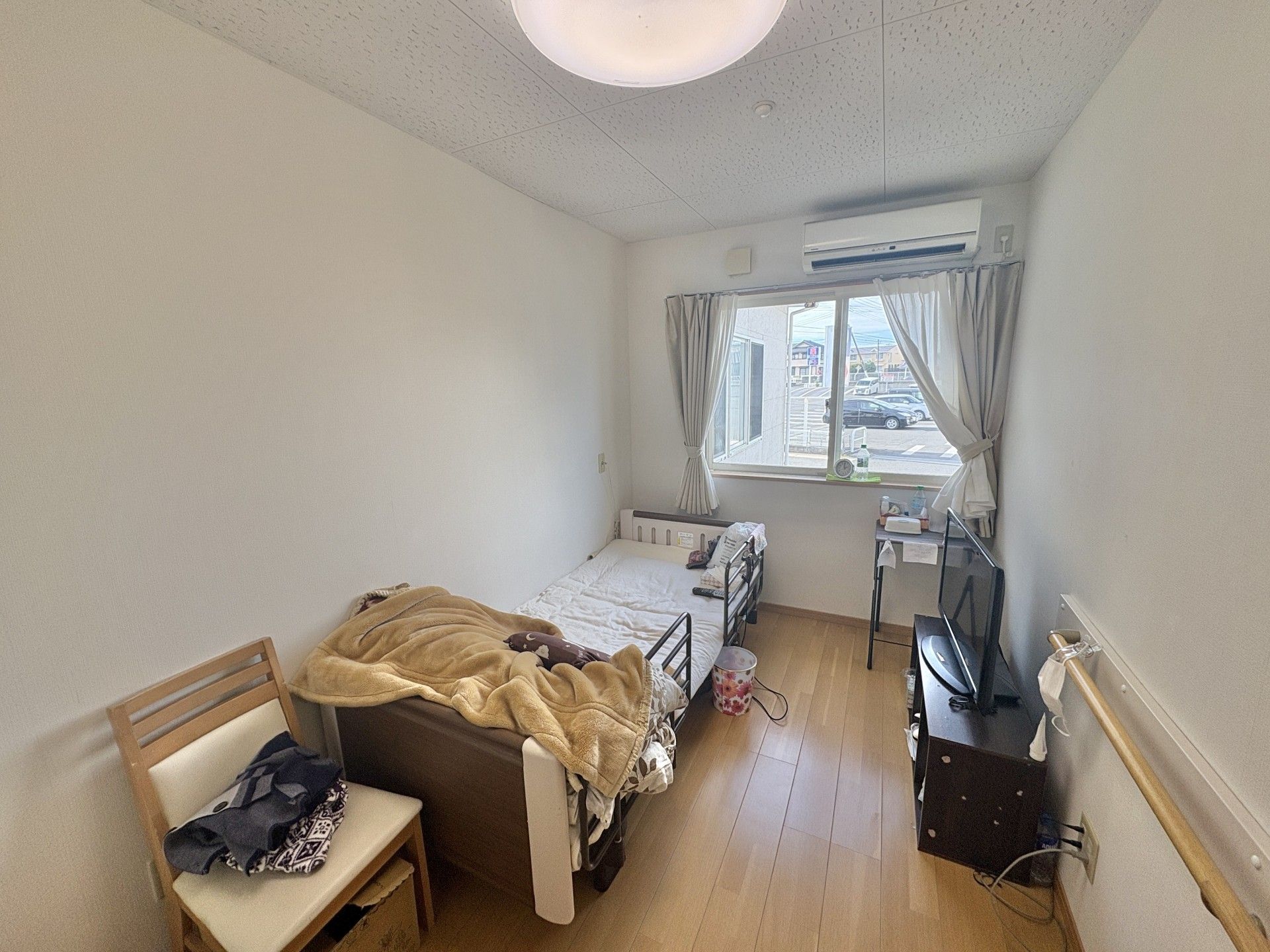 車椅子に乗って外出する高齢男性と付き添う女性ヘルパー